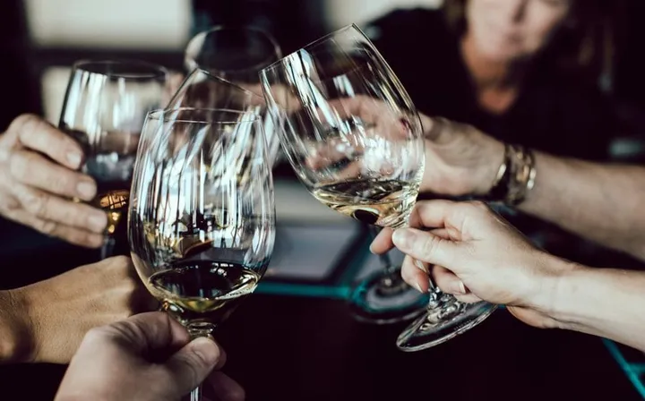 Friends clinking wine glasses at a dinner table
